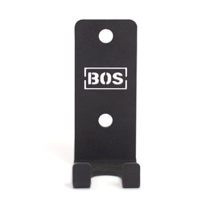 The Bells of Steel Hanging Barbell Holders are black, rectangular metal mounts labeled "BOS," featuring two mounting holes and a lower lip to securely store your barbells in your lifting gallery.