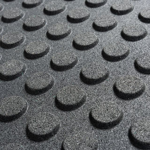Close-up of Bells of Steel Rubber Flooring Gym Mat 24" x 24" (Set of 2), featuring a textured gray surface with evenly spaced, raised circular bumps—ideal for anti-slip or tactile home gym flooring.