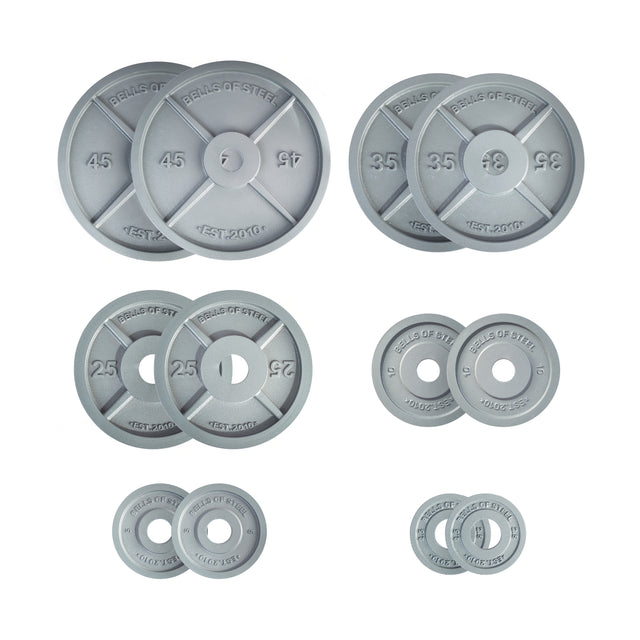 The Bells of Steel Machined Iron Olympic Weight Plate Sets include eight pairs in 45, 35, 25, 10, 5, and 2.5 lb sizes—each embossed with "BELLS OF STEEL," "TEST-200KG," and made for a precision fit on Olympic bars.