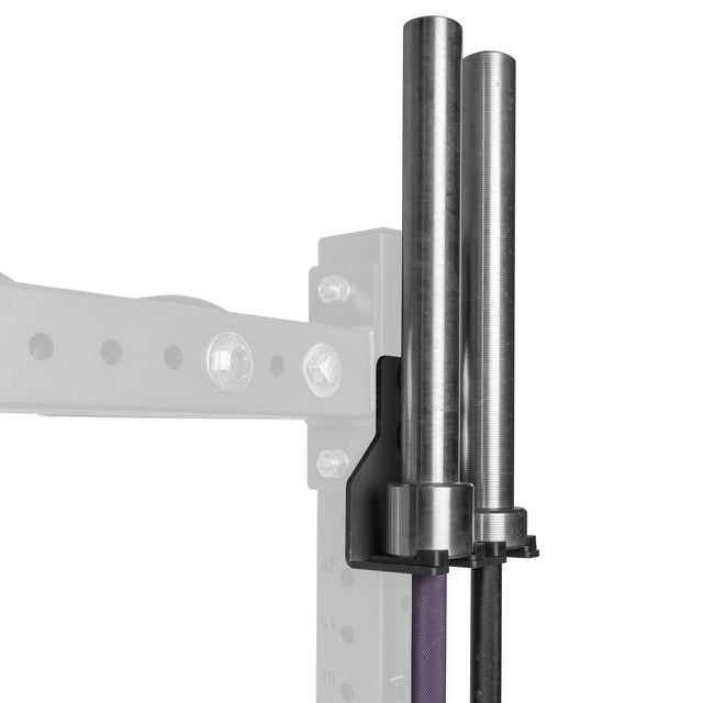 The Bells of Steel Hanging Barbell Holders, in black metal, mount onto a squat rack to securely store two barbells vertically. The faded squat rack and background emphasize the practical barbell storage solution.