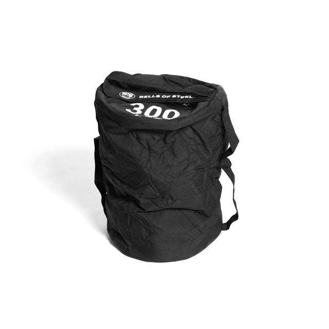 A black Bells of Steel Fitness Sandbag with handles stands upright on a white background, highlighting its durable cylindrical design.