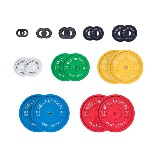 Bells of Steel's Calibrated Powerlifting Plates - LB Sets are colorful and organized by size, featuring black, white, green, yellow, blue, and red plates. Each has calibrated weights in pounds with "Bells of Steel Est. 2010," ensuring standardized diameters for precision.