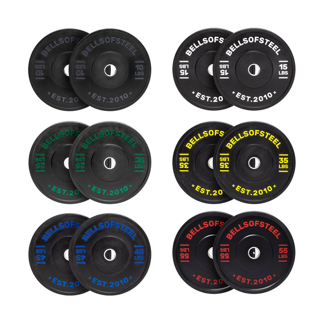 The Bells of Steel Dead Bounce Conflict Bumper Plate Sets include eight pairs of black plates (10–55 lbs), each with color-coded text and a logo. Made from durable virgin rubber with stainless steel inserts for lasting performance.