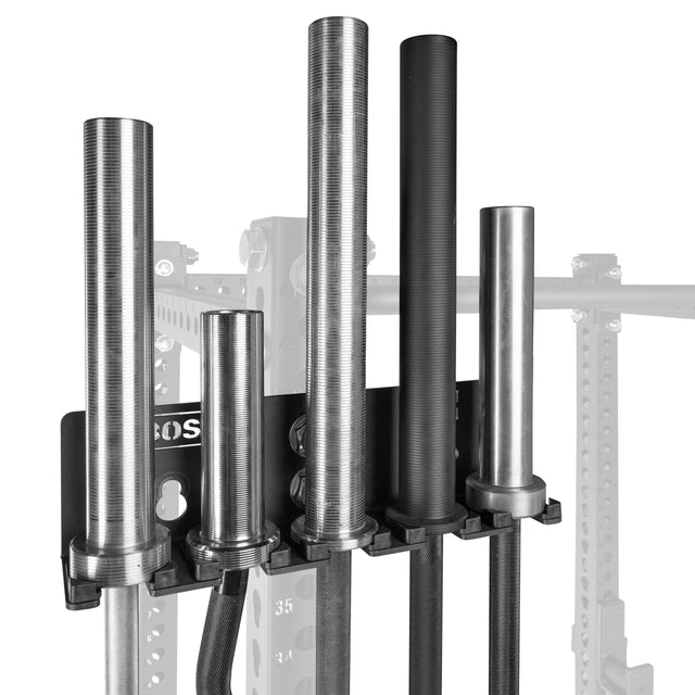 The Bells of Steel Hanging Barbell Holders, in black metal, are mounted on gym equipment and securely store four upright, knurled barbells. The holders and bars stand out clearly against a grayscale background.
