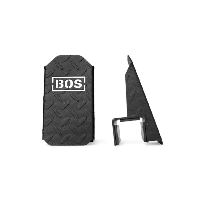 Two black, textured, rectangular Bells of Steel Footplates for Cable Tower/All-In-One Trainer; one shows the BOS logo front view, the other displays a side profile with a stand or clip—perfect as an accessory for added stability.