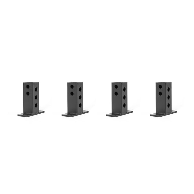 Four black metal brackets with rectangular bases and vertical structures feature multiple circular holes, evenly spaced on a white background, ideal as wall connectors for Hydra & Manticore racks. Product: Folding Rack Wall Connectors & Hinges. Brand: Bells of Steel.