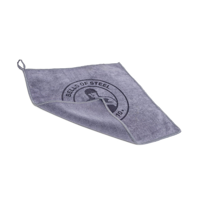 The Bells of Steel Barbell Cleaning Microfiber Towel is a gray, lint-free towel with stitched edges, a hanging loop, and the Bells of Steel logo—ideal for cleaning barbells. Shown on a white background.