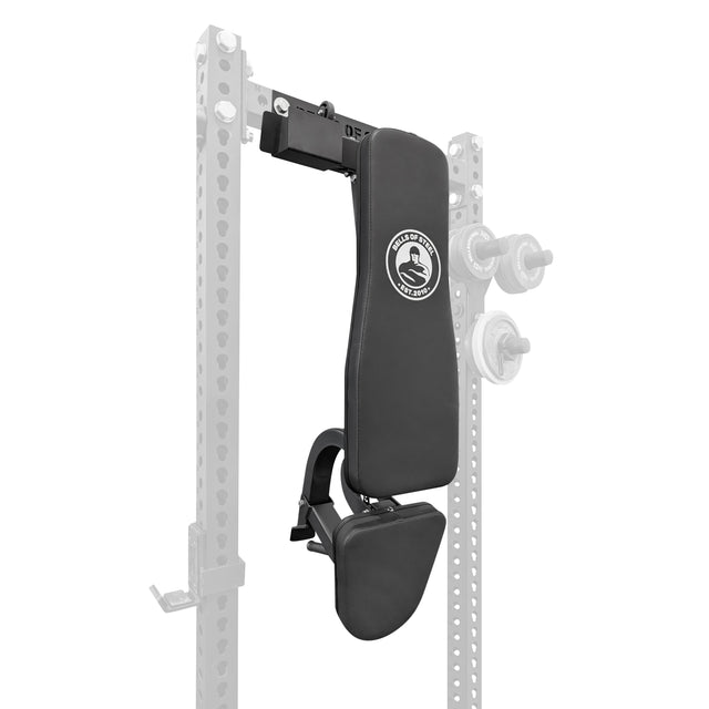 The Bells of Steel Wall or Rack Mounted Bench Hanger displays a black adjustable bench with padded back and head support, shown vertically mounted on a metal fitness rack. Faded weight plates and rack parts appear in the background.