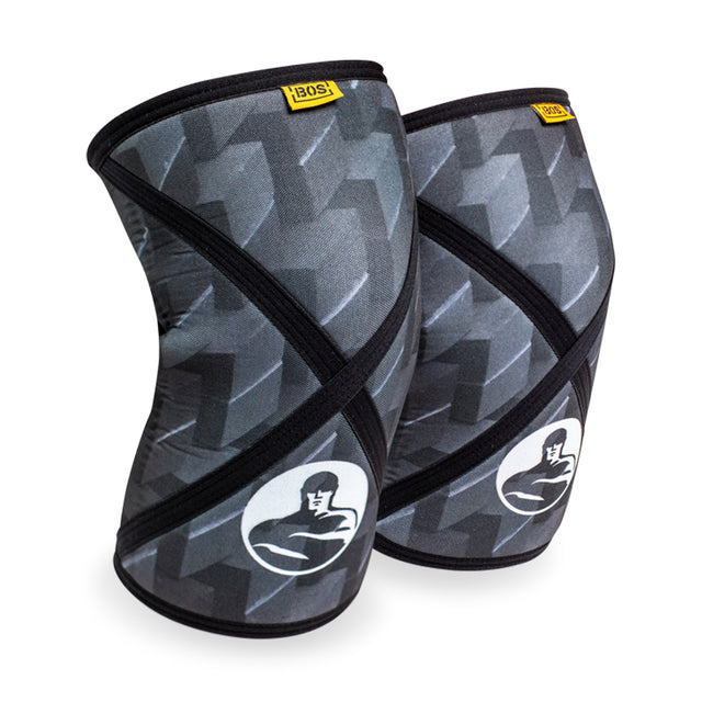 Bells of Steel Knee Sleeves feature black and gray patterns, a flexing arm logo, and a yellow top label, delivering reliable knee support for squats or weightlifting.
