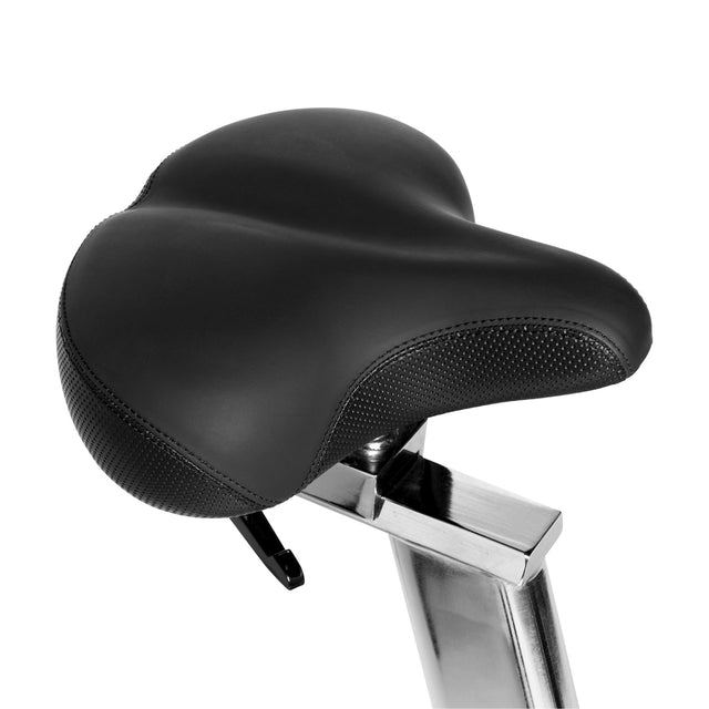A close-up of the black, cushioned seat on the Bells of Steel Blitz Air Bike, mounted on a silver post against a white background—ideal for boosting comfort during intense home gym sessions.