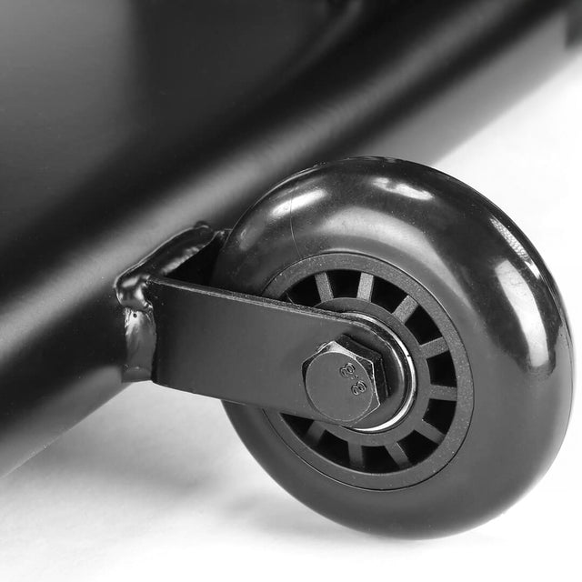 Close-up of a small black caster wheel with visible center spokes, attached to the metal frame of the Bells of Steel Blitz Air Bike, resting on a white surface.