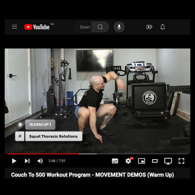 In a home gym, someone does a squat thoracic rotation stretch next to deadlift and bench press equipment, a treadmill, and a large monitor displaying the YouTube interface for "Couch to 500kg - Workout Program" by Bells of Steel.