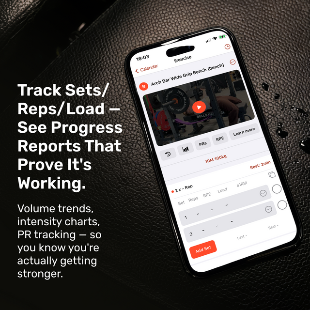 On a textured black surface, a smartphone shows the Bells of Steel Training App, featuring exercise tracking, progress reports, PR tracking, and intensity charts—perfect for home gym users from Bells of Steel.
