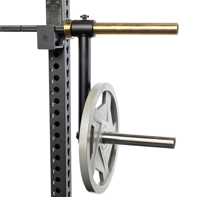 A close-up of the Bells of Steel Camber Bar Attachment - Pair mounted on a gym rack with multiple holes for height adjustment, holding a single weight plate, with an Olympic barbell resting on top.