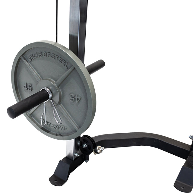 A close-up of a "BELLS OF STEEL 45 LB" weight plate on a storage peg, mounted to the Cable Crossover (2.3" x 2.3" Racks) gym machine by Bells of Steel; part of the metal frame, pulley system, and floor are partially visible.