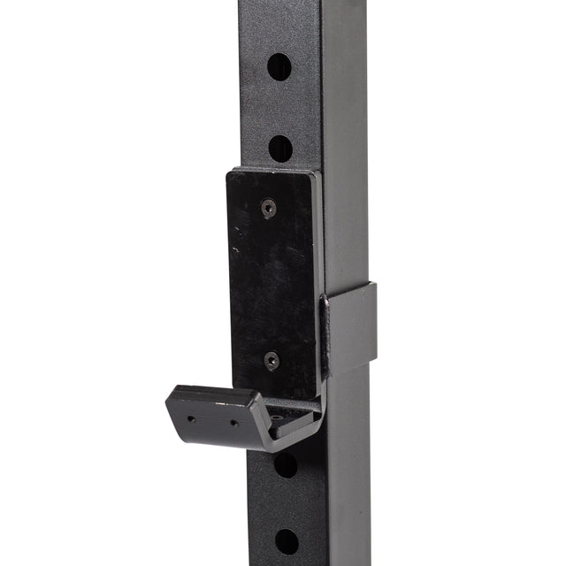 Close-up of a black metal J-hook rack attachment by Bells of Steel, secured to a vertical Cable Crossover (2.3" x 2.3" Racks) post with multiple holes, designed for weightlifting and pulley system use.