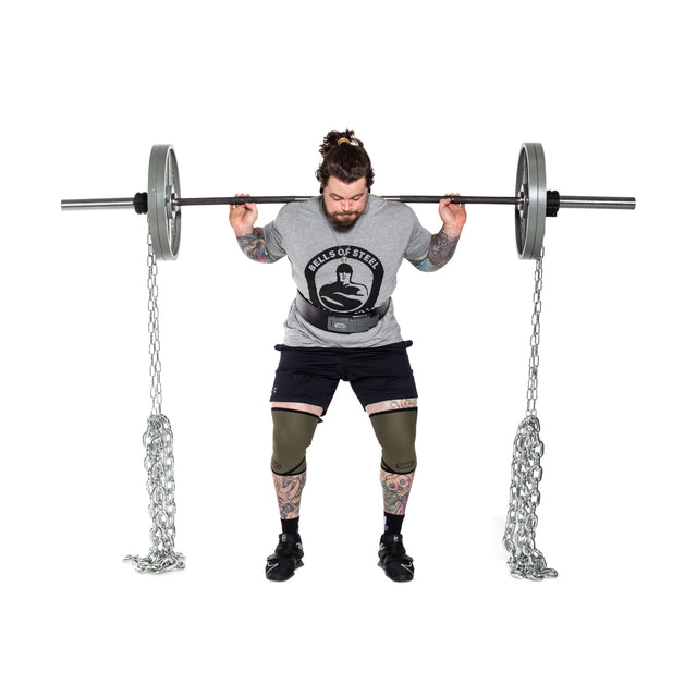 A person squats with a barbell loaded with weight plates and Bells of Steel Weightlifting Chains, which add progressive resistance, against a white background.