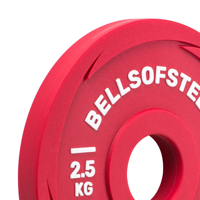 A close-up of a red Urethane-Coated Change Plate by Bells of Steel, marked “2.5 KG” in white, with a central hole for barbell use—ideal for accurate weight adjustments during workouts.
