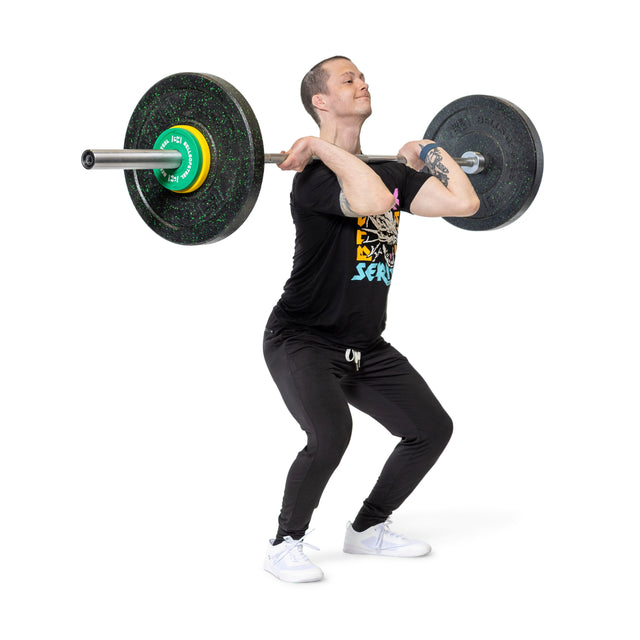 Dressed in black athletic wear, a person lifts a loaded barbell with Bells of Steel Urethane-Coated Change Plate Sets to their shoulders, ready for a squat or clean, highlighting the plates’ strength and durability against a plain white backdrop.