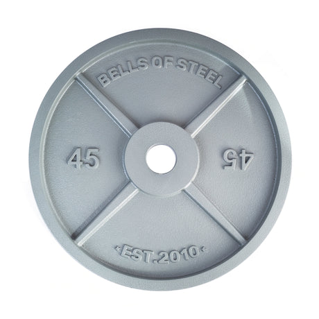 The Machined Iron Olympic Weight Plate by Bells of Steel is a gray, 45-pound iron plate with "Bells of Steel" and "EST. 2010" embossed on the front, featuring a precision-cut center hole for barbell compatibility.