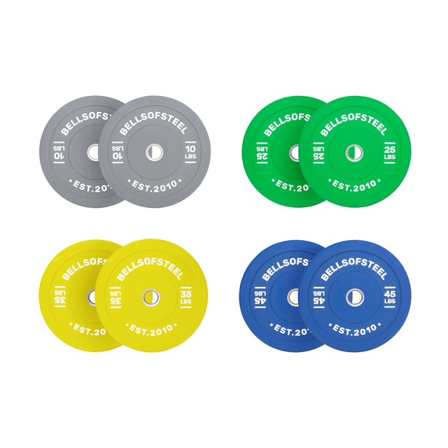 The Bells of Steel Coloured Bumper Plate Sets include four pairs—gray (10 lbs), green (25 lbs), yellow (35 lbs), and blue (45 lbs)—each with a stainless steel insert, branding, weight, and year mark for precise training.