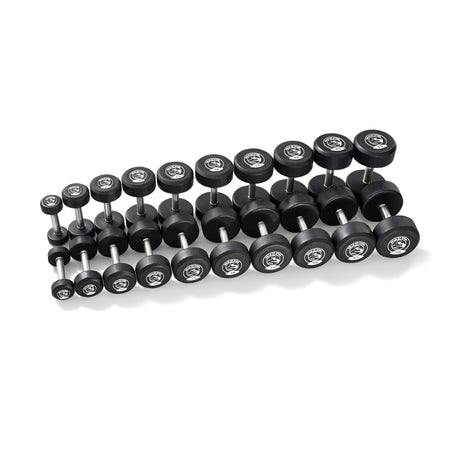 Bells of Steel Urethane Dumbbell Sets, featuring black urethane and stainless steel heads with silver handles, are arranged in three rows by weight, highlighting their commercial-grade quality against a white background.