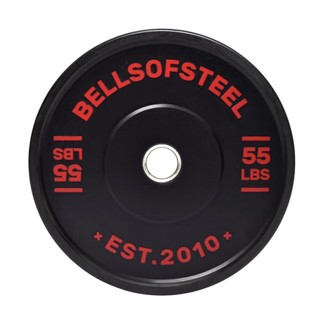 A 55-lb Dead Bounce Conflict Bumper Plate features red lettering with "BELLSOFSTEEL" and "EST. 2010" around the center hole, and has a durable stainless steel insert for lasting performance.