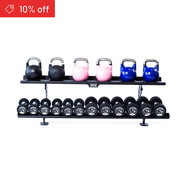 A red “10% off” label appears on the top left of the Bells of Steel Commercial Interchangeable Weight Rack, which holds three black, two pink, and two blue competition kettlebells above black urethane dumbbells on its swappable bottom shelf.