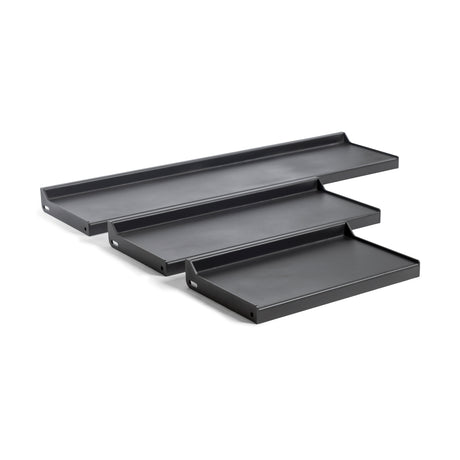 The Bells of Steel Dumbbell/Kettlebell Shelf features four black, rectangular metal shelves with raised edges and visible mounting holes, ideal for displaying collections or storing gear. These wall-mounted shelves are shown in a staggered arrangement for versatile functionality.