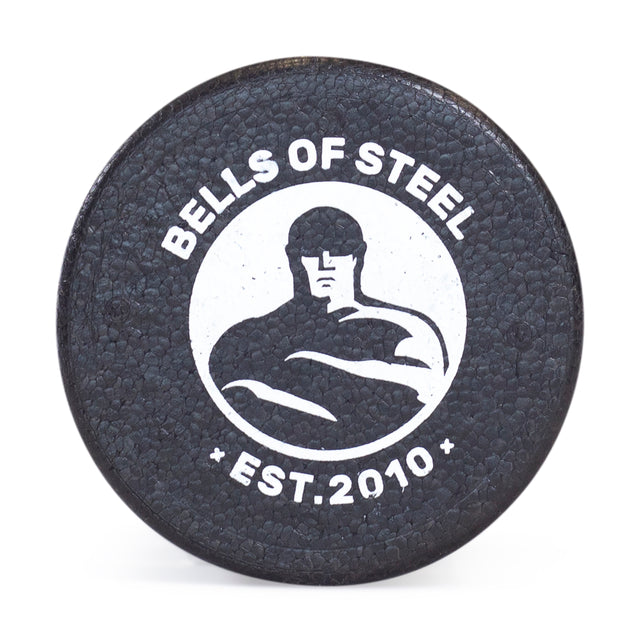 A black foam roller from Bells of Steel features a textured surface with their logo, a muscular figure, and “EST. 2010” in white—ideal for aiding post-workout recovery.
