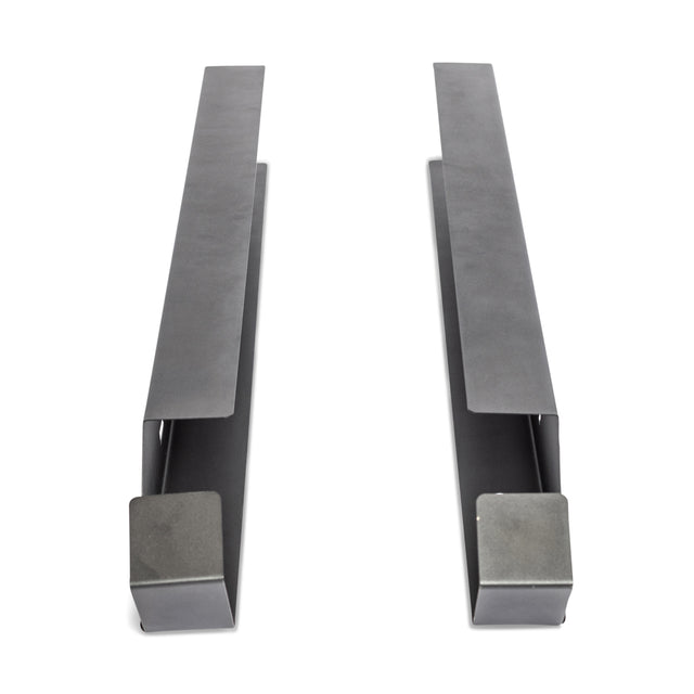 Two gray metal brackets from the Bells of Steel Foam Roller Storage are displayed parallel on a white background, each with a wide flat base at one end and a narrower, tapered shape at the other—ideal for wall mounting.