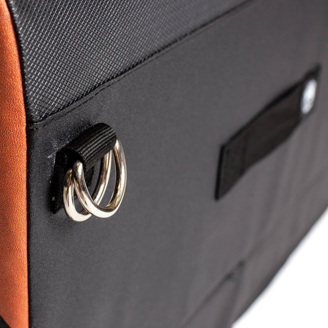 Close-up of a black and brown Bells of Steel Soft Glute Bench with two metal rings on a fabric loop and a small black side patch—ideal for carrying your glute bench or hip thrust bench accessories.