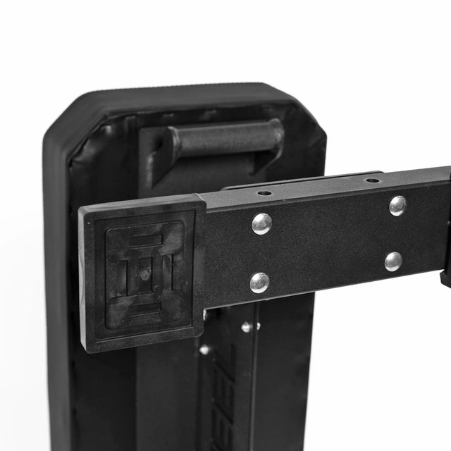Close-up of a black padded shield with a handle and rectangular mounting bracket, like those on the Bells of Steel Hero Heavy-Duty Weight Bench (1,000lb capacity). The bracket is secured with metal bolts.