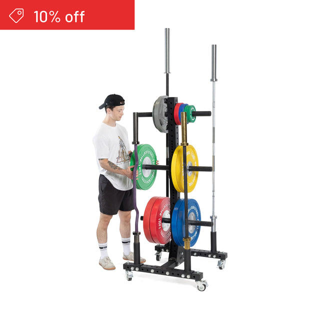 A person organizes colorful weights on the Bells of Steel Hydra Bumper Plate Tree Builder, which has two vertical barbell holders. A red "10% off" banner is in the top left. Ideal for tidy home gym storage. White background.
