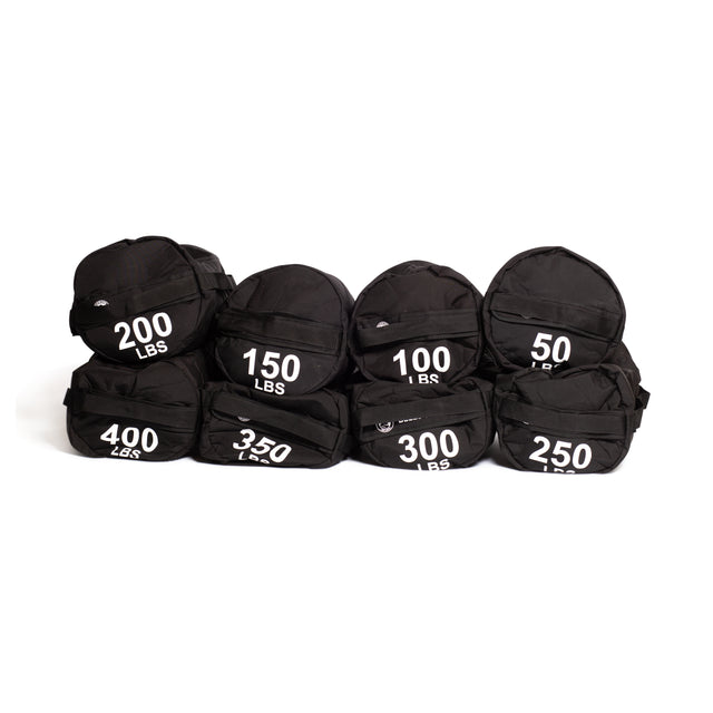 Seven black Bells of Steel Fitness Sandbag Sets, labeled in white with weights from 50 to 400 lbs, are stacked in two rows against a white background, ready for versatile sandbag workouts.
