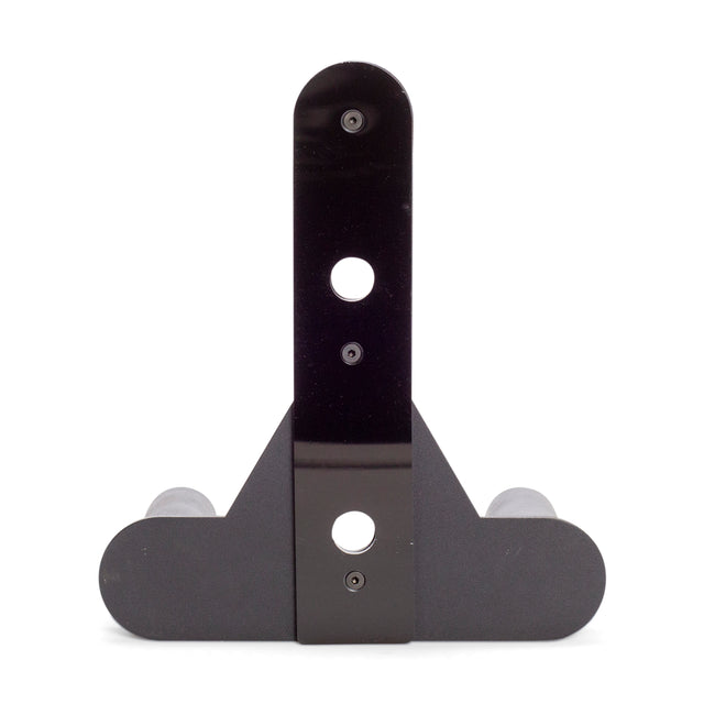 The Bells of Steel Change Plate Storage Pegs are black, T-shaped metal brackets with rounded edges and three screw holes, featuring two gray rollers at the base—perfect for mounting Olympic change plates on your power rack.
