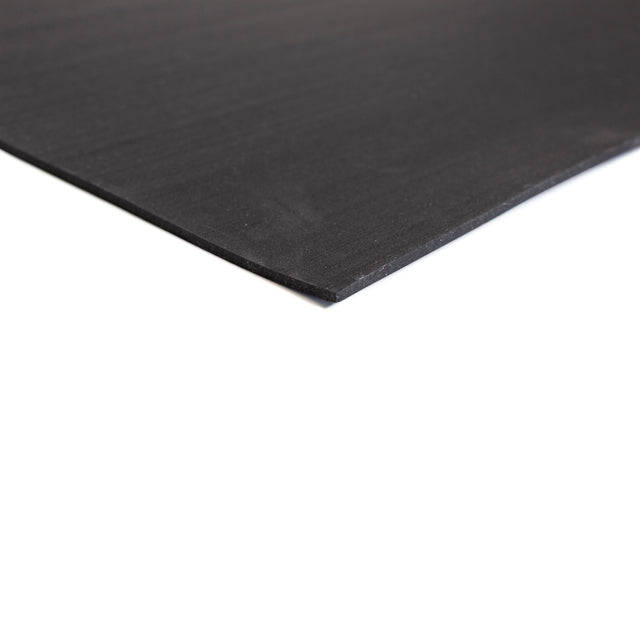 A close-up of the corner of a flat, thin black Bells of Steel Premium Rubber Flooring 4' x 6' sheet on a white background.