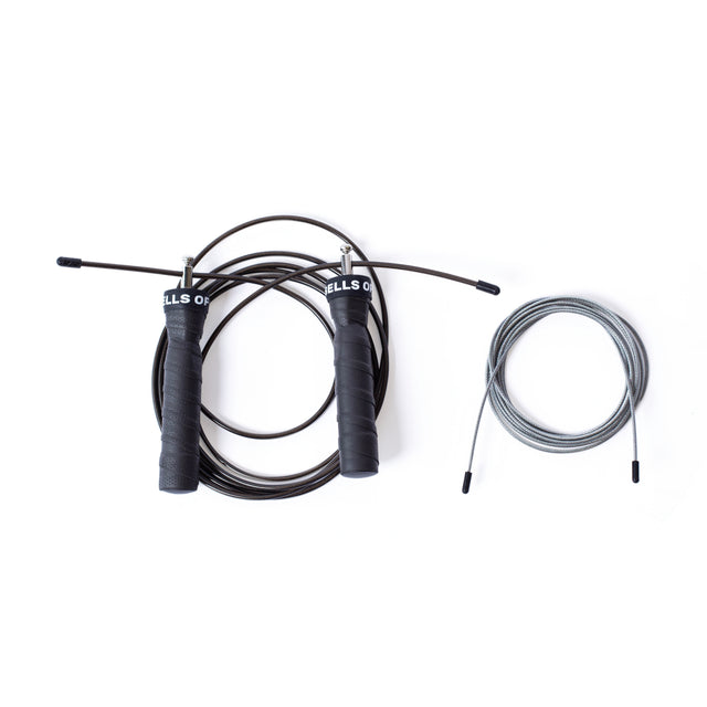 The Bells of Steel Jump Rope features a black adjustable design with ergonomic handles and a metal wire, ideal for cardio. It includes a spare silver cable replacement, all set against a white background.