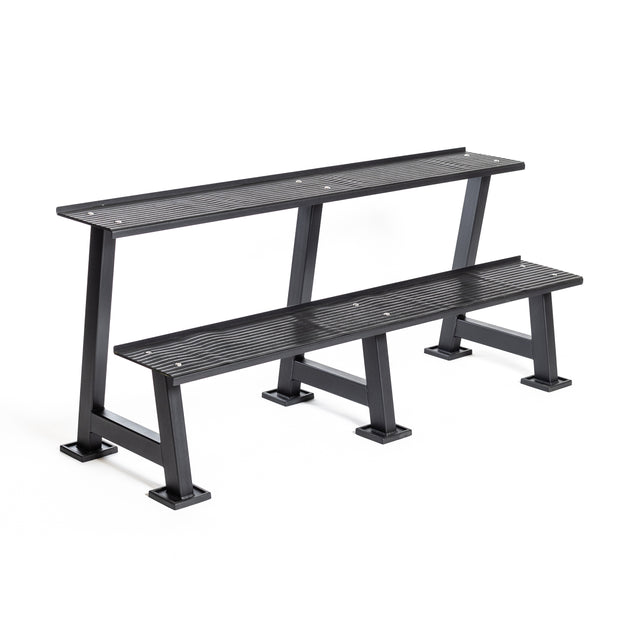 The Bells of Steel Kettlebell Rack is a two-tiered black metal bench with slatted seats and sturdy legs, ideal for public or home gym use, and doubles as a practical competition kettlebell storage solution.