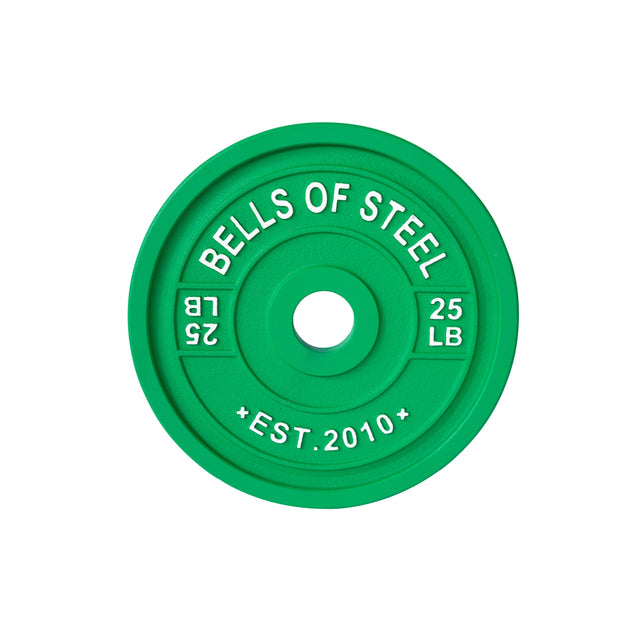 A green, 25 LB calibrated plate from Bells of Steel, featuring "BELLS OF STEEL" and "EST. 2010" in white, is tailored for precision training with a center hole for barbell placement.