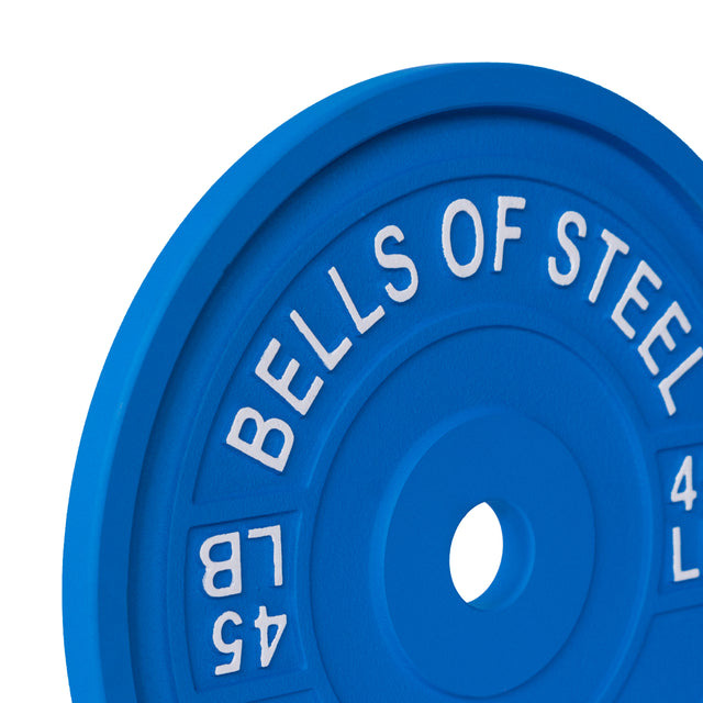 A close-up of a blue "Bells of Steel" calibrated powerlifting plate, embossed in white with "45 LB" and "4 KG," set against a white background, perfect for serious training.