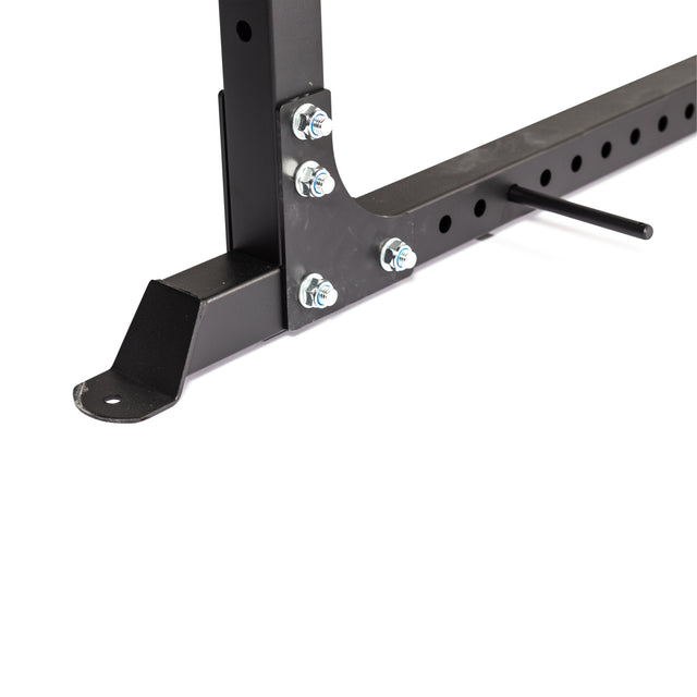 Close-up of the Bells of Steel Light Commercial Power Rack (2.3" x 2.3", ⅝" holes) black metal frame with bolts, nuts, adjustment holes, protruding pin, and flat base featuring a mounting hole for barbell safety straps.