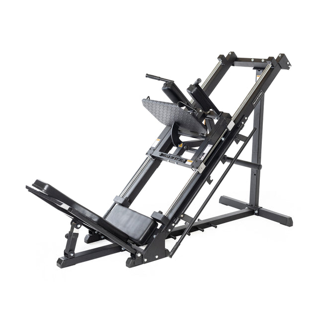 The Bells of Steel Leg Press Hack Squat Machine is a black metal 2-in-1 gym or home gym unit with angled rails, padded backrest, footplate, and handles for effective lower body weight training exercises.