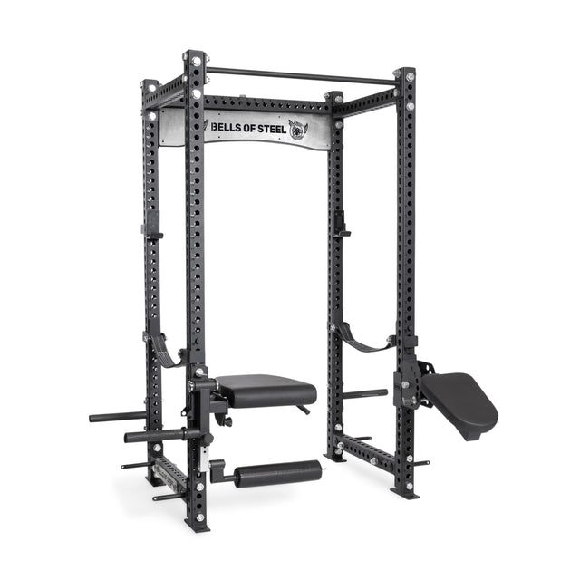 The Manticore Four Post Power Rack - Prebuilt (3" x 3", 1" holes) by Bells of Steel features a bench, leg holder, weight plate holders, and branded crossbar—ideal for serious strength training in your home gym.