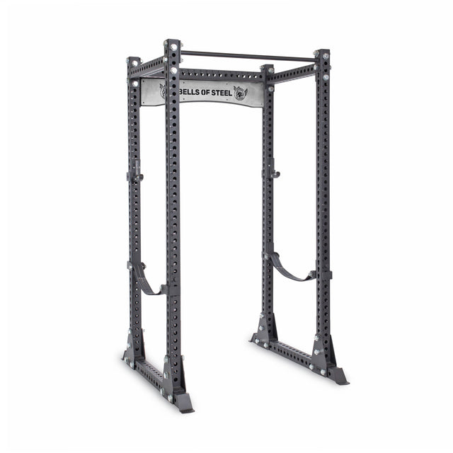 The Bells of Steel Manticore Flat Foot Power Rack (3" x 3", 1" holes) features adjustable holes and safety bars, ideal for weightlifting and home gyms; sleek black and silver design with branded top crossbar.