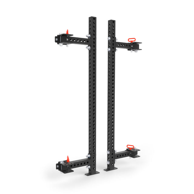 The Bells of Steel Manticore Folding Half Rack (3" x 3", 1" Holes) features two black metal squat rack posts with adjustable arms and red pins, offering a sturdy modular solution for weightlifting in any home gym.