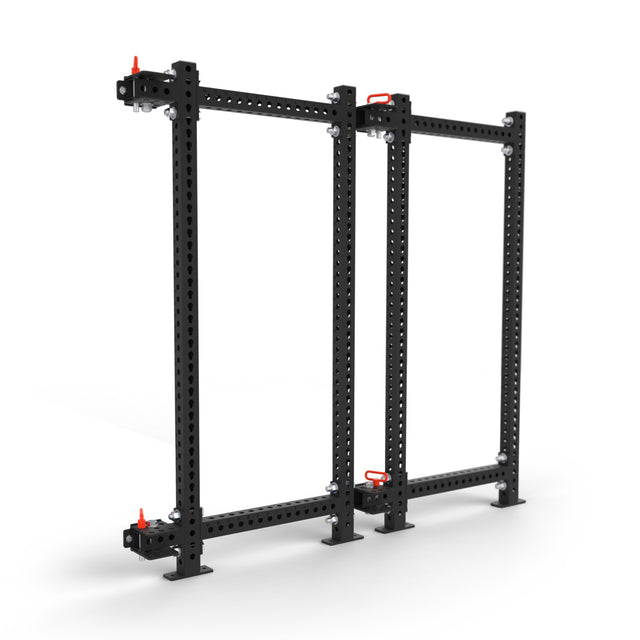 The Bells of Steel Manticore Folding Power Rack - Prebuilt (3" x 3", 1" Holes) is a black metal modular rack with two horizontal beams, three vertical supports, multiple attachment holes, and red locking pins—ideal for home gyms or industrial spaces.