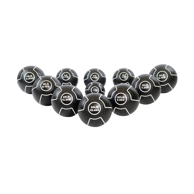 Nine Mighty Grip Medicine Balls from Bells of Steel are arranged in a V shape on a white backdrop. Each ball features a superior grip design with weight labels in pounds and kilograms, ranging from 10LB to 30LB, and has dark coloring with crisp white text.