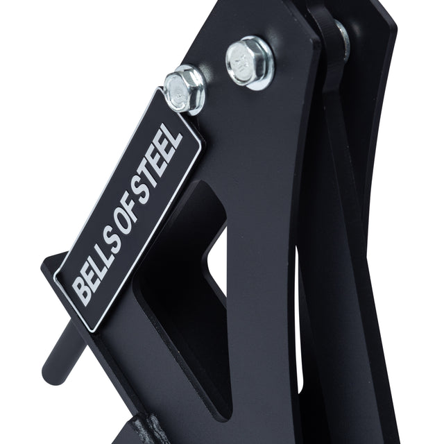 Close-up of the Bells of Steel Monolift Rack Attachment in black metal, featuring bolts and angular, space-saving components with a visible "BELLS OF STEEL" label.