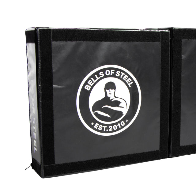 Black Deadlift Platform Drop Pad Pair by Bells of Steel, features a white "BELLS OF STEEL EST. 2010" logo with a muscular figure. Reinforced edges add durability; ideal for absorbing impact and protecting floors during workouts.